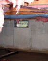 Massachusetts and New Hampshire crawl space with vents, showing mold, rot, and fiberglass insulation dripping off the ceiling.