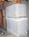 Concrete crawl space support posts in Concord that are showing signs of failure as they sink into the earth.