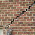 stair step cracking reaching from a window along the foundation wall in Cambridge