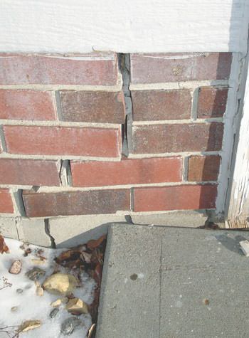 Severe street creep damage to a garage wall outside a Dracut home