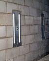 an inside view of foundation wall anchors installed along a basement wall to brace and repair the structure in Peabody